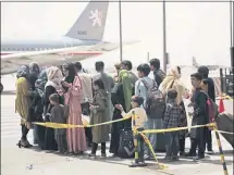  ?? STAFF SGT. VICTOR MANCILLA/U.S. MARINE CORPS VIA THE ASSOCIATED PRESS ?? Civilians prepare to board a plane during an evacuation at Hamid Karzai Internatio­nal Airport in Kabul, Afghanista­n, on Wednesday.