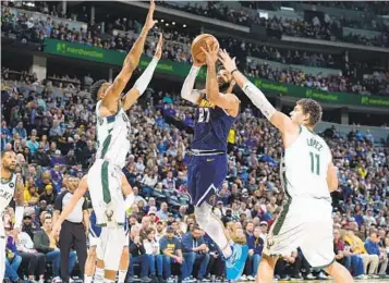  ?? DAVID ZALUBOWSKI AP ?? Nuggets guard Jamal Murray, who had 35 points, drives to the basket between Bucks defenders.