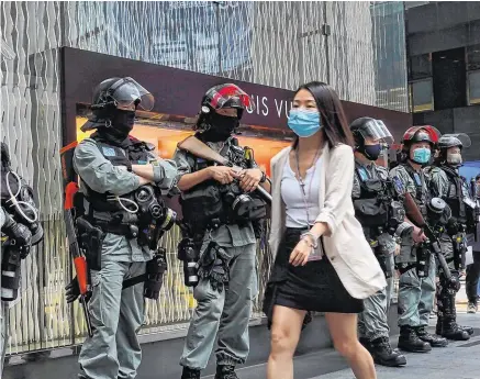  ?? PHOTO AP ?? Fraught:
A woman and police in Hong Kong on the second day of debate on a bill that would criminalis­e abusing the Chinese anthem.
