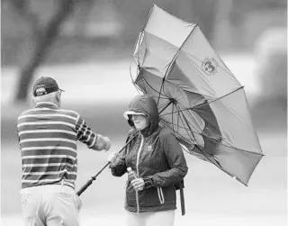  ?? SAM GREENWOOD/GETTY ?? A fan’s umbrella turns inside out during the pro-am prior to the Sony Open in Hawaii at the Waialae Country Club on Wednesday in Honolulu, Hawaii. Windy conditions are expected during the tournament.