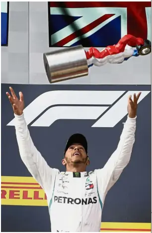  ?? — AP ?? Confident: Mercedes’ Lewis Hamilton throwing the trophy in the air after winning the French Grand Prix on Sunday.