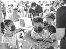  ?? Sam Owens / Staff file photo ?? Emily Mancha, 6, watches her mother Amelia Tovar comfort her brother Hector Mancha, 8, as he gets a vaccine in Hidalgo.