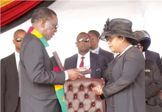  ?? — Picture: Justin Mutenda ?? President Mnangagwa hands over the Zimbabwe flag to national hero Professor Ngwabi Bhebe’s widow, Faith, during his burial at the National Heroes Acre in Harare yesterday.
