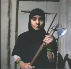  ??  ?? Kashmiri girl Muskan, 14, displays outside her home an ax the family carries with them when they go outdoors at night to protect themselves from wild animals at Dardkhor village, on the outskirts of Srinagar, Kashmir.