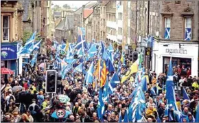  ?? ANDY BUCHANAN/AFP ?? Pro-independen­ce activists wave Scottish Saltire flags as they march from Holyrood to the Meadows in Edinburgh, Scotland on Sunday.