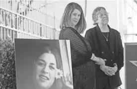  ?? CHRIS PIZZELLO/INVISION/AP ?? Owen Elliot-Kugell, daughter of Cass Elliot, looks at a portrait of her mother as she stands with her aunt Leah Kunkel in 2022.