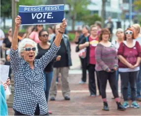  ??  ?? Jane Pitz holds up a sign during the We Believe Them rally Saturday in downtown South Bend, Ind.