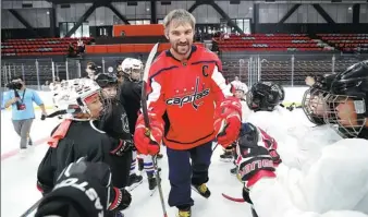  ?? PROVIDED TO CHINA DAILY ?? Alexander Ovechkin, captain of the Washington Capitals and the NHL’s official ambassador to China, exchanges high-fives with kids at a youth camp in Beijing on Monday.