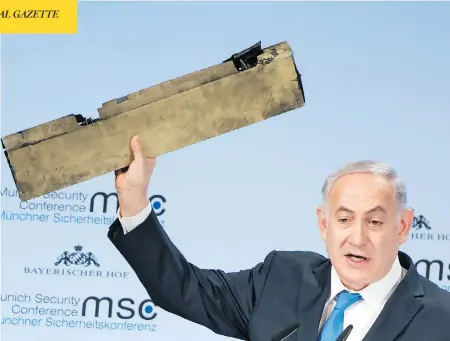  ?? AFP PHOTO / MSC MUNICH SECURITY CONFERENCE / LENNART PREISS ?? Israeli Prime Minister Benjamin Netanyahu holds up what he claims is a piece of an Iranian drone shot down in Israeli airspace as he gives a speech during the Munich Security Conference on Sunday. Netanyahu warned Tehran over aggression­s from the...