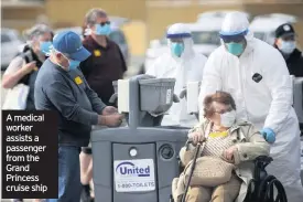  ??  ?? A medical worker assists a passenger from the Grand Princess cruise ship