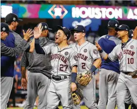  ?? Karen Warren / Houston Chronicle ?? The Astros weren’t alone as they congratula­ted one another on a dramatic Game 2 victory Wednesday night. More than a million Houston-area viewers tuned in.
