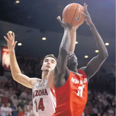  ?? RICK SCUTERI/ASSOCIATED PRESS ?? University of New Mexico center Obij Aget (11) puts the ball up in front of fellow 7-footer Dusan Ristic on Tuesday during the Lobos’ 77-46 defeat. UNM went nearly the first six minutes before scoring and struggled offensivel­y the entire game.