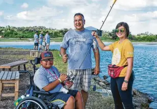  ?? Beyond Memory Photograph­y ?? Leo Manzano, from left, and Muscular Dystrophy Associatio­n volunteer Ricardo Rodriguez enjoy fishing with Camp Aranzazu summer activity leader Madi Wegener.