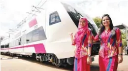  ?? BERNAMAPIX ?? ERL staff Nordalili Azmi (right) and Izzati Liyana Yusof posing with one of the new trains at the ERL depot in Salak Tinggi, Sepang.