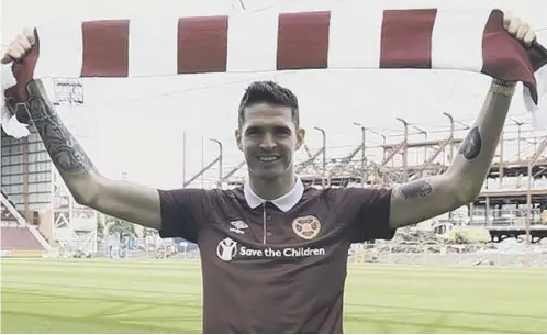  ??  ?? 0 Striker Kyle Lafferty is all smiles as he dons a Hearts shirt for the first time during his unveiling at Tynecastle yesterday afternoon.