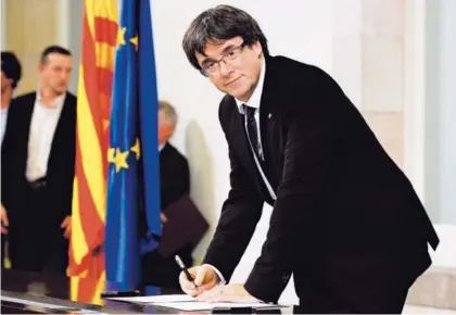  ?? AFP ?? Carles Puigdemont firmó el 10 de octubre un documento sobre la independen­cia de Cataluña.