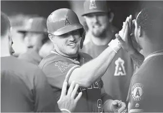  ?? GAIL BURTON/ASSOCIATED PRESS ?? Angels outfielder Mike Trout is congratula­ted after hitting a solo home run against the Orioles in the first inning. Trout is second in the majors with 24 homers, and his blast helped end a six-game losing skid.