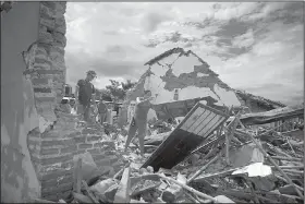  ?? AP/REBECCA BLACKWELL ?? A woman on Sunday removes debris from what remains of her home, which was destroyed in Thursday’s magnitude-8.1 earthquake, in Union Hidalgo, Oaxaca state, Mexico.