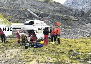  ?? PHOTOS: TIM ROBINS/GREYMOUTH RESCUE HELICOPTER ?? Complex rescue . . . An injured climber is loaded into a rescue helicopter in Aoraki/Mt Cook National Park.