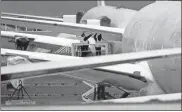  ?? Mike Siegel/The Seattle Times/TNS ?? Boeing employees work on a wing section of a 777X outside the factory in Everett, Washington, in April 2020.