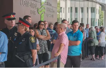  ??  ?? Des citoyens ont fait la queue jeudi pour rendre hommage aux policiers décédés. - La Presse canadienne: Keith Minchin