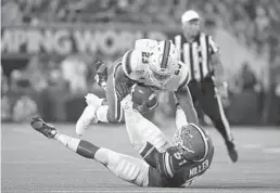  ?? MARK BROWN/GETTY IMAGES ?? Miami’s Cam’Ron Harris runs over Florida’s Ventrell Miller. The Gators hung on to win, 24-20.