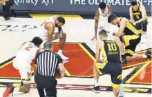  ?? KIM HAIRSTON/BALTIMORE SUN ?? Players and officials take a knee before a men’s basketball game between Maryland and Iowa at Xfinity Center.