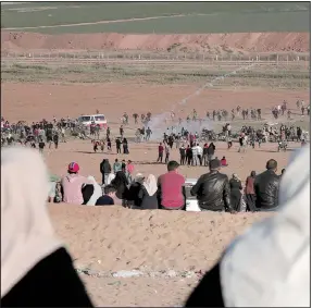  ?? AP/ADEL HANA ?? Palestinia­n women watch from a hill as Israeli soldiers fire tear gas at protesters Sunday during clashes along the Gaza border with Israel, east of Beit Lahiya, Gaza Strip.