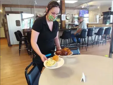  ?? ZACHARY SRNIS — THE MORNING JOURNAL ?? Tabitha Van Gilder, manager of Four Keys Restaurant in Columbia Station, brings out a plate of ribs.