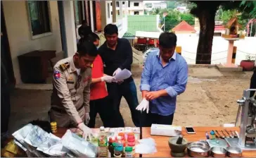  ?? SUPPLY ?? Police inspect hundreds of tablets, packets and bottles of drugs during raids that led to the arrest of five foreigners in Preah Sihanouk late last year.