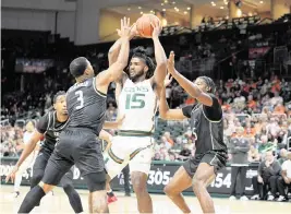  ?? JC RIDLEY Miami Hurricanes Athletics ?? Norchad Omier gets triple-teamed during the Hurricanes’ game Friday against UCF. Omier finished with 19 points and 12 rebounds as all five Canes starters scored in double figures.