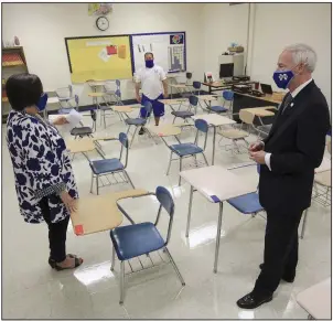  ?? (Arkansas Democrat-Gazette/Staton Breidentha­l) ?? Gov. Asa Hutchinson talks with health teacher Scott Johnson (background) and Principal Susan White as he tours Monticello High School on Wednesday after his daily coronaviru­s briefing. More photos at arkansason­line.com/813governo­r/.