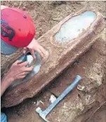  ?? Ericka Karner ?? CONSTRUCTI­ON WORKERS inspect the child-size metal casket found last May. Windows in the coffin revealed the preserved body of the girl, whose identity was a mystery.