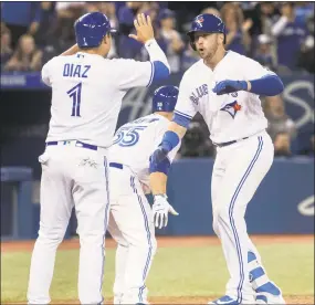  ?? Fred Thornhill / Associated Press ?? The Blue Jays’ Justin Smoak, right, is greeted at home plate by Aledmys Diaz and Russell Martin after hitting a grand slam against the Yankees in the eighth inning on Sunday in Toronto.