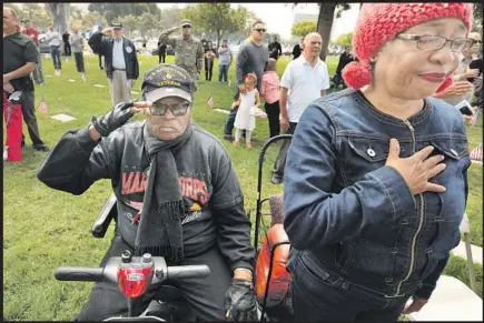  ??  ?? THE HOMELESS couple salute during a Memorial Day ceremony at the Los Angeles National Cemetery, where the mayor spoke.