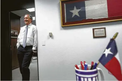  ?? Jon Shapley / Houston Chronicle ?? Texas Attorney General Ken Paxton has adorned his office with state symbols, including a signed Dallas Cowboys jersey.