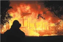  ?? Justin Sullivan / Getty Images ?? A Geyservill­e home burns during the Kincade Fire, which broke out despite PG&E’s shutoffs throughout the state.