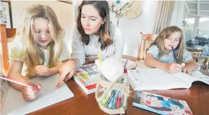  ?? Photo / Warren Buckland ?? Anneke Erasmus with daughters Esme` , 4, and Liane` , 7, doing their schoolwork.