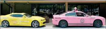  ?? Keith Bryant/The Weekly Vista ?? Capt. Seth Kallick with the Bella Vista Fire Department stands with a Pink Heals vehicle parked next to a Cancer Challenge vehicle outside Riordan Hall. While the groups have no formal affiliatio­n, Kallick said he came out to show support for the event.