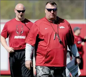  ?? NWA Democrat- Gazette/ ANDY SHUPE ?? Arkansas Razorbacks Coach Bret Bielema ( right), watching a recent practice with strength and conditioni­ng coach Ben Herbert, said the different angles the team was taking on defense during Saturday’s scrimmage helped put the offense on alarm.