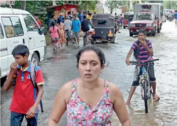  ??  ?? Kelaniya: Residents prepare to evacuate as waters rise. Pix by Indika Handuwala, Lal S. Kumara and M.D. Nissanka