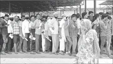  ?? SATISH BATE/HT PHOTO ?? A photograph taken last May showing migrant residents of Govandi queueing up for police passes to return home