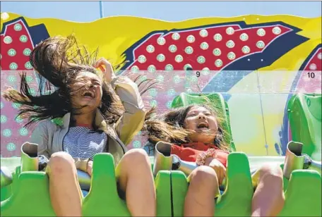  ?? Liz Moughon Los Angeles Times ?? FRIENDS Chloe Nguyen, 12, left, and Audrey Jung, 11, are all smiles on the Jungle Trip ride at the Orange County Fair in Costa Mesa.