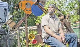  ??  ?? Danny Killion, owner of Weathered Wood, sits in his yard on Tuesday in Troy. Killion’s landlord instructed him to board up his storefront.