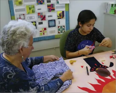  ?? SOCIAL JUSTICE SEWING ACADEMY VIA AP ?? This photo provided by the Social Justice Sewing Academy shows Yesenia Madrid creating a social justice art quilt with the help of SJSA Volunteer, Lynn Hickman at Bay Quilts in Richmond