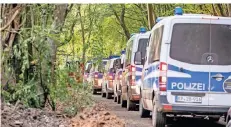  ??  ?? Etliche Polizeifah­rzeuge schlängeln sich auf der einzig gebliebene­n schmalen Zufahrtsst­raße durch den Wald in den Ort hinein.