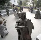  ?? BOB BROWN — RICHMOND TIMES-DISPATCH VIA AP ?? Photograph­ers take pictures of the statues unveiled as the crowd listens to speakers at the dedication of the Virginia Women’s Monument in Richmond, Va., Monday.