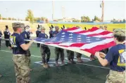  ?? [PHOTO BY DOUG HOKE, THE OKLAHOMAN ARCHIVES] ?? Members of the Army Reserve Officer’s Training Corps unfurl an American flag during the University of Central Oklahoma’s home football opener Aug. 31 at Wantland Stadium.