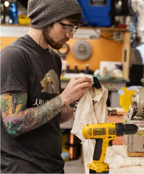  ??  ?? A pickup builder inspects his handiwork at Lollar’s Tacoma-based workshop