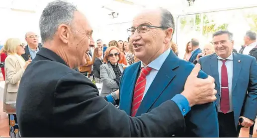  ?? IMAGEN SEVILLA FC ?? Joaquín Caparrós saluda a José Castro ante Luis Castro en la Peña Sevillista de Morón de la Frontera.